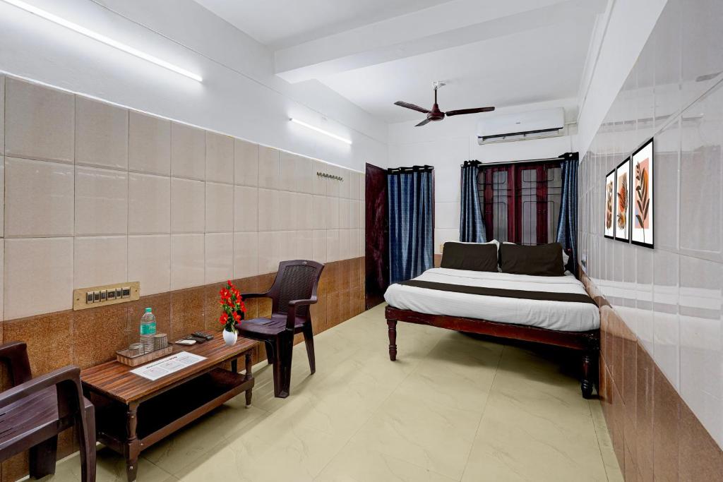 um quarto com uma cama, uma mesa e uma escrivaninha em Hotel O Rock Beachview Pondicherry Formerly Varsha Residency em Pondicherry