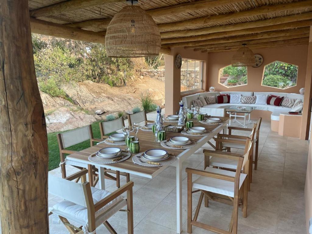 uma mesa de madeira e cadeiras em um pátio em Apartment In Porto Cervo em Porto Cervo