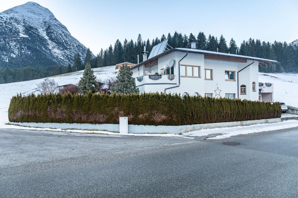 une maison blanche sur le côté d'une route dans l'établissement Ferienwohnung Paula, à Platzl