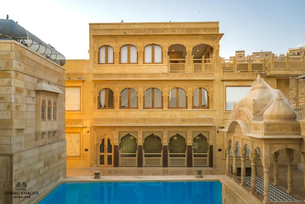 a building with a swimming pool in front of it at Hotel Grand Khalifa in Jaisalmer