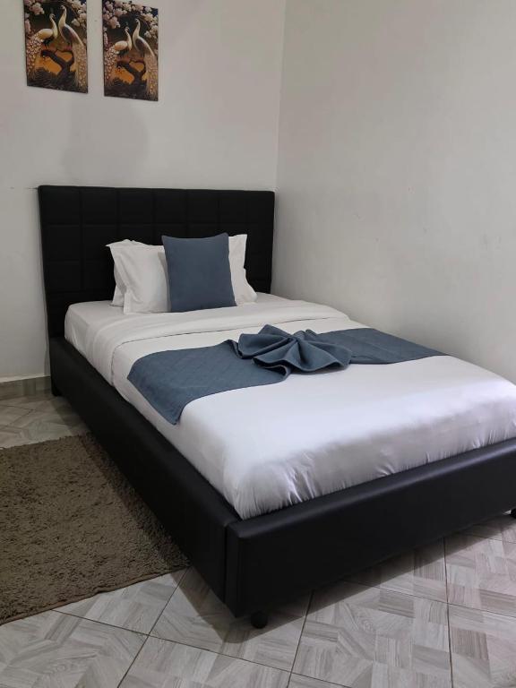 a large bed with a black headboard in a room at The lit garden place in Kisumu