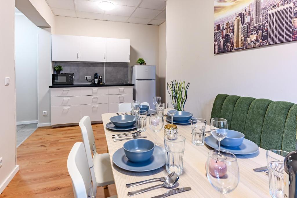 a dining room with a table with plates and glasses at Etagenwohnung 110qm in der Villa Winckelmann in Berlin