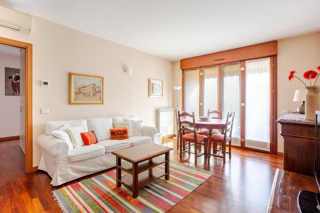 a living room with a white couch and a table at Casa Mike - Trilocale con garage in San Giuliano Milanese