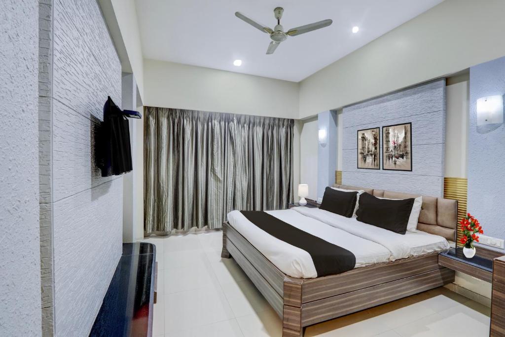 a bedroom with a large bed and a window at Townhouse Kakinada Nagamalli Thota Junction in Kākināda