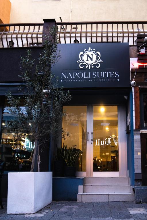 a store with a sign on the side of a building at Napoli Suites Studios Aparthotel in St. Julianʼs