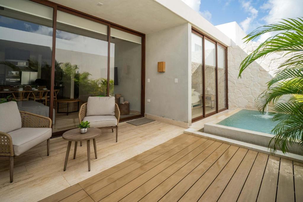 een patio met een zwembad en 2 stoelen en een tafel bij Luxury Designer Villa Pool & Gym in Cancun