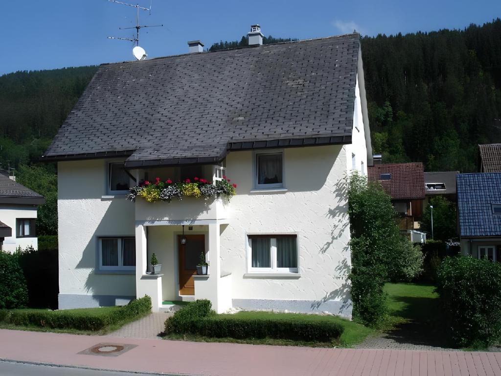 a white house with flowers in a window at Haus Barbara Ott in St. Blasien