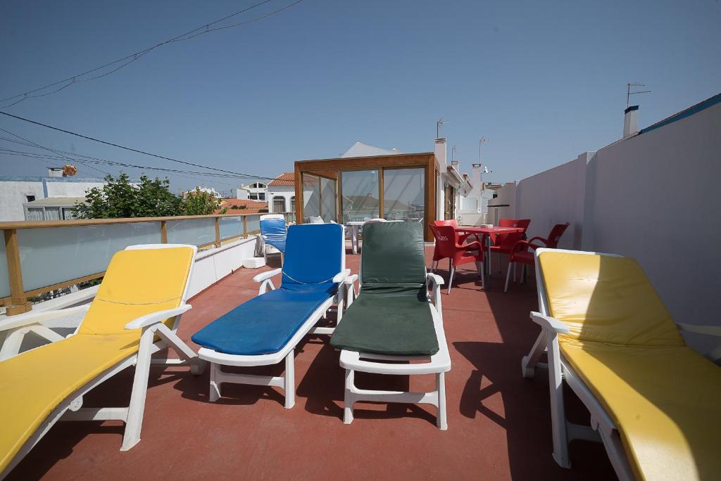 a group of chairs and tables on a balcony at Vilas de Ribamar in Ribamar