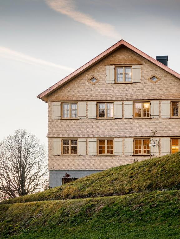 a large house on top of a grassy hill at Ferienhaus Halwina hideaway in Sibratsgfäll