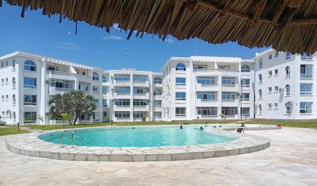 een zwembad voor een groot appartementencomplex bij Malindi Modern 2BR Apartment in Malindi