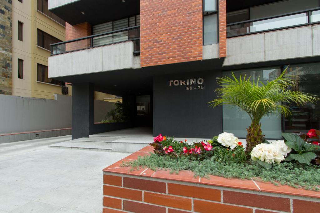 un muro di mattoni con fiori davanti a un edificio di Suites Metropoli Edificio Torino a Quito