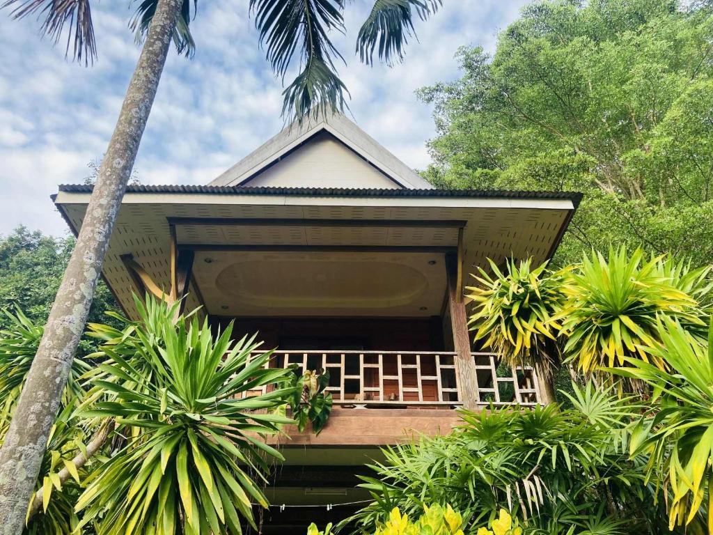 a house with palm trees in front of it at Pizza classic resort kohjum in Ban Ko Phrao