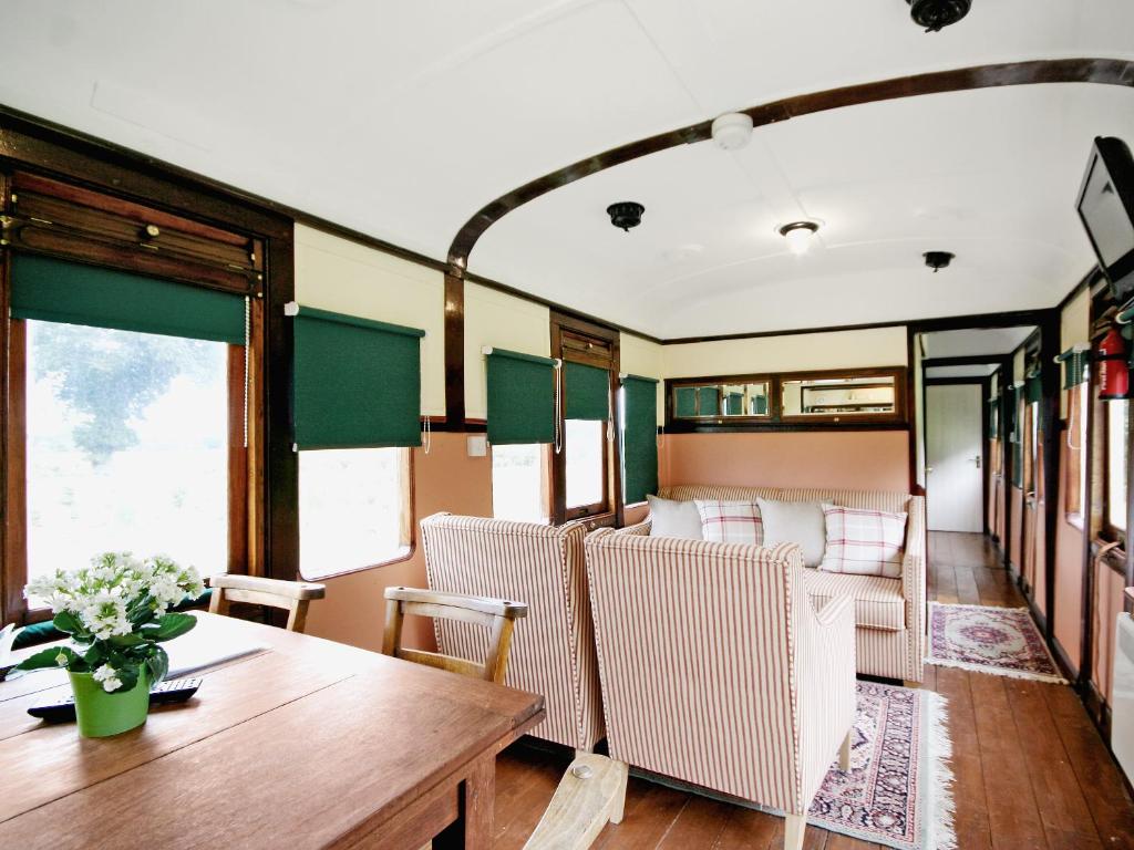 a dining car of a train with a table and chairs at Railway Carriage Two - E5601 in Wetheringsett