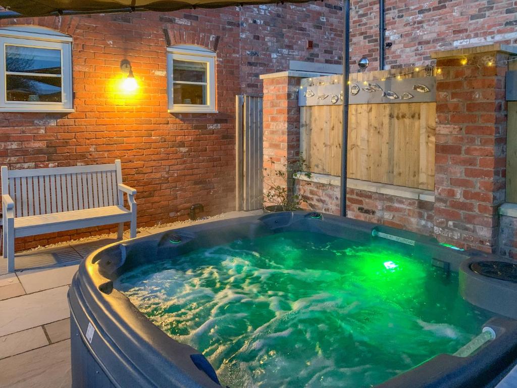 a jacuzzi tub in a backyard with a bench at White Heather Barn in Swanwick