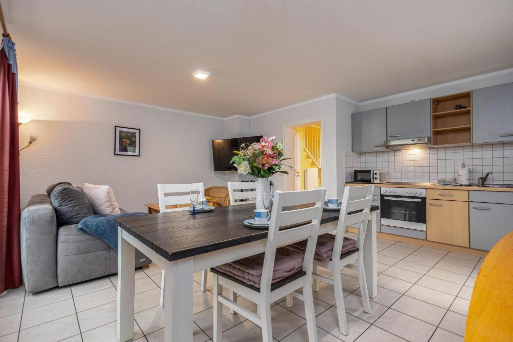 a kitchen and living room with a table and chairs at Reihenendhaus Celebes in Dierhagen