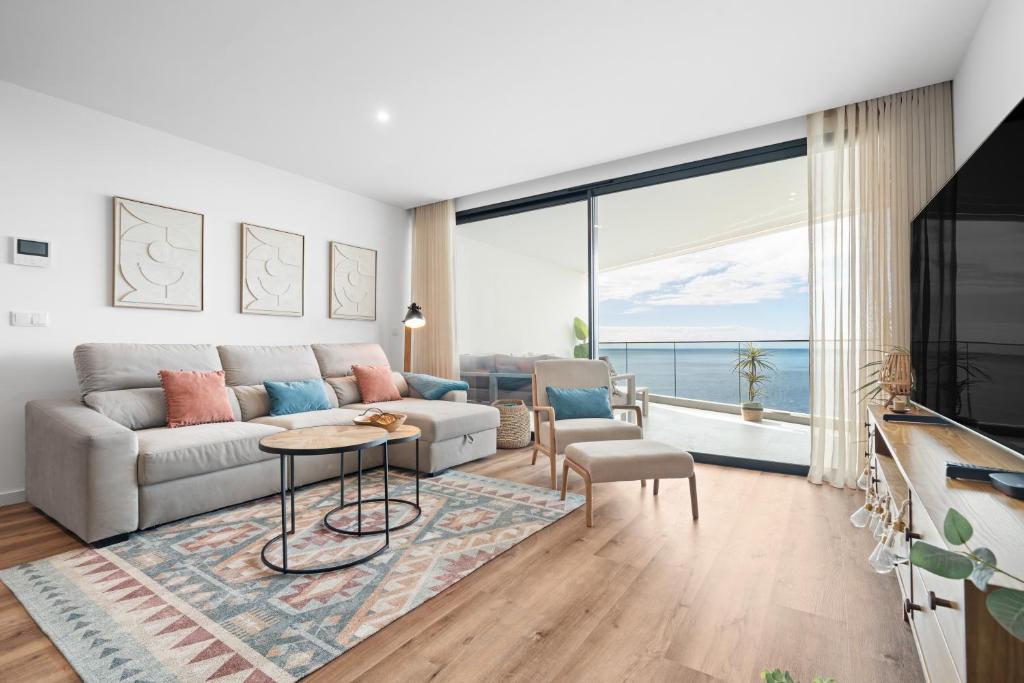 een woonkamer met een bank en een groot raam bij Peace Haven III in Câmara de Lobos
