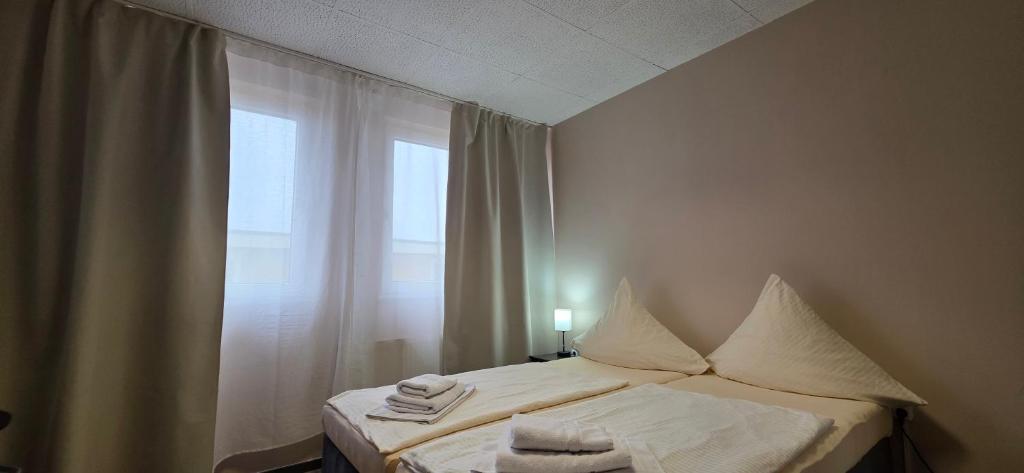 een slaapkamer met een bed met handdoeken erop bij Pension M in Neurenberg