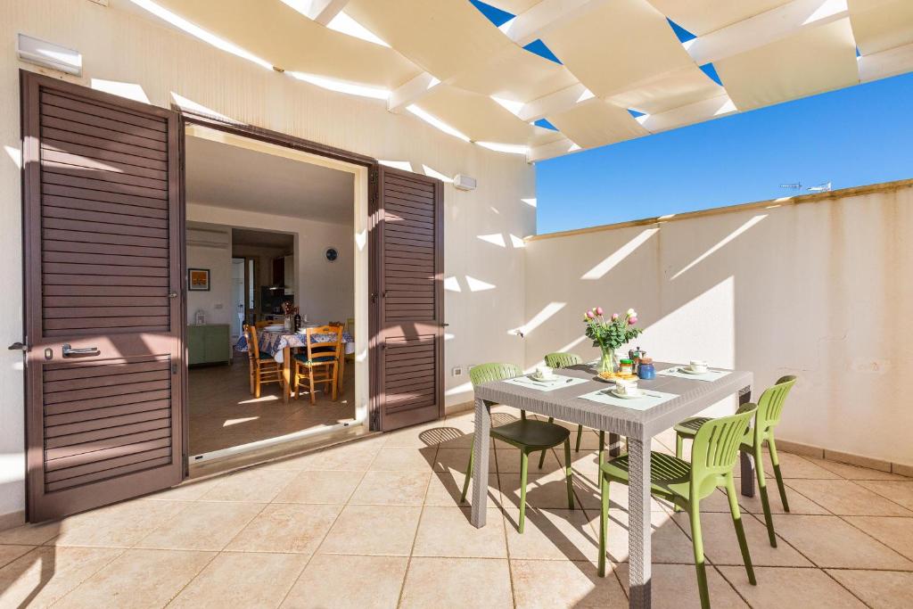 een eetkamer met een tafel en groene stoelen bij Casa Agnese by BarbarHouse in Leuca