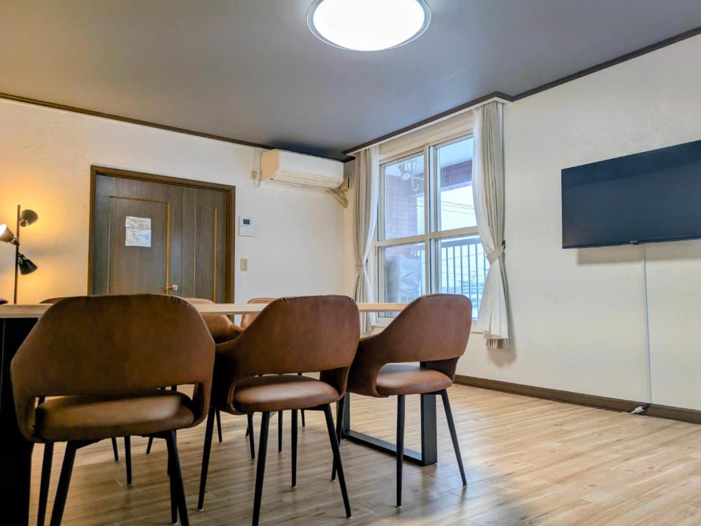 een eetkamer met een tafel en vier stoelen bij Frasis in Furano