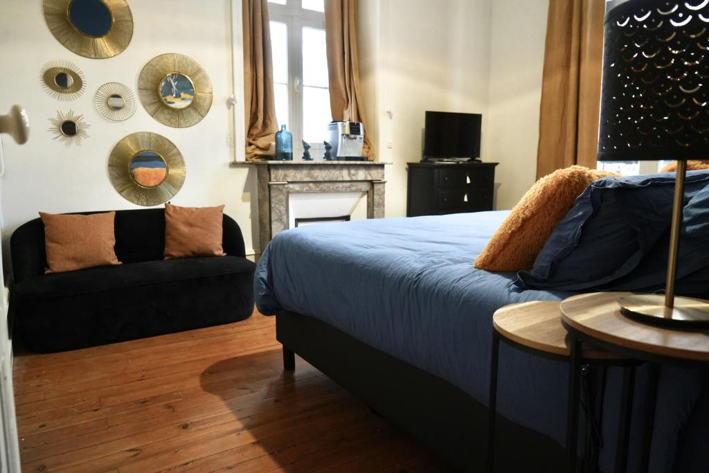 a bedroom with a bed and a couch at Domaine des Monts de la Baie in Mareuil-Caubert