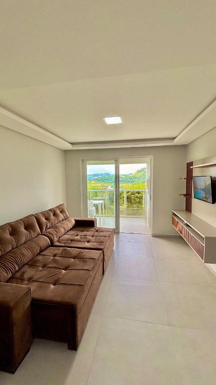 ein großes Wohnzimmer mit einer Couch und einem großen Fenster in der Unterkunft Dubai Thermas Piratuba 406 in Piratuba