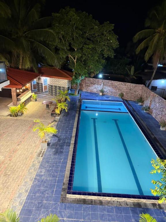 a large blue swimming pool in front of a house at Omar Villa in Bentota