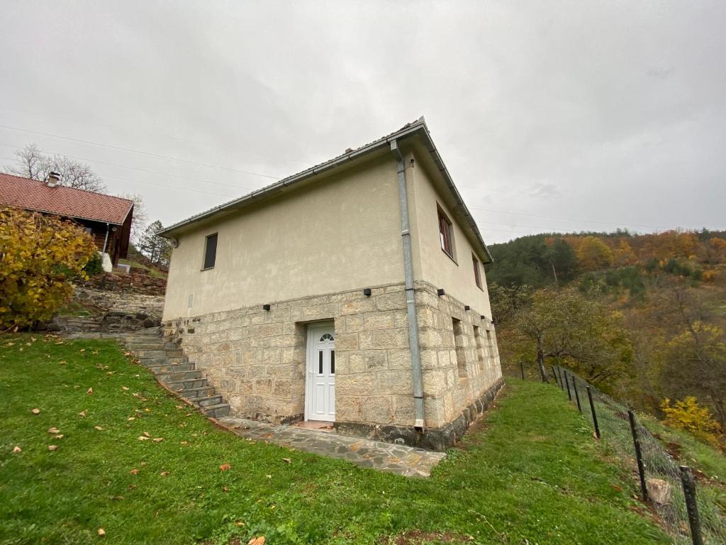 a brick building with a white door on a grass field at FoRest Apartment 