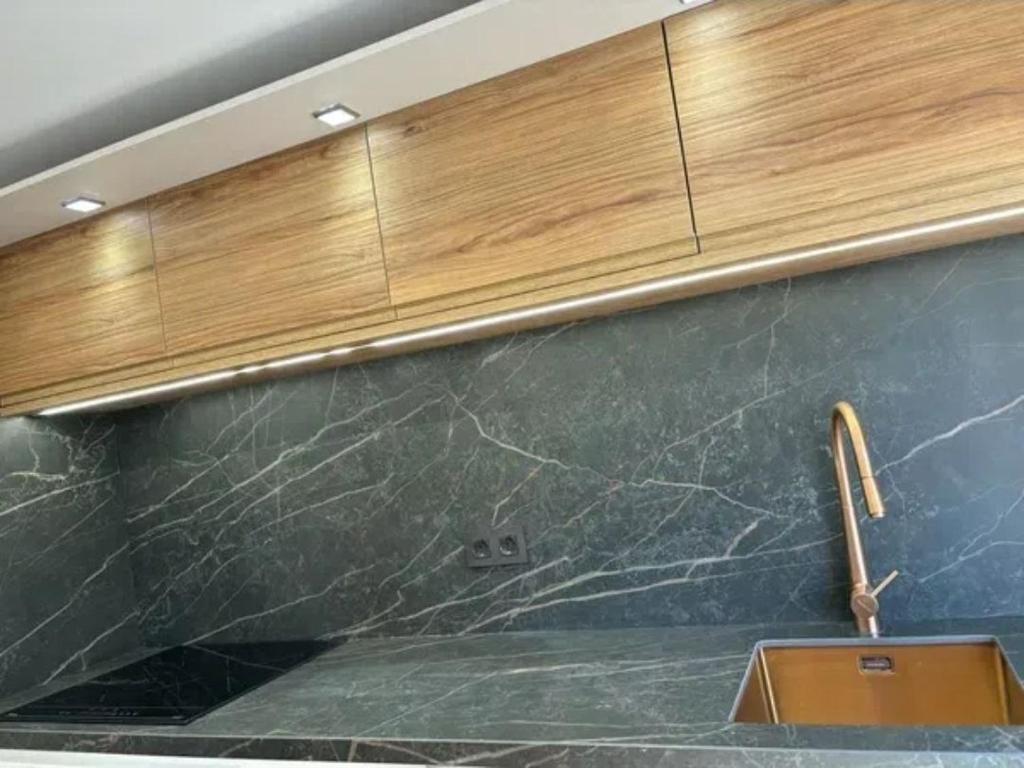 eine Küche mit Spüle und Holzschränken in der Unterkunft Dulzena Stay Apartments in A Coruña