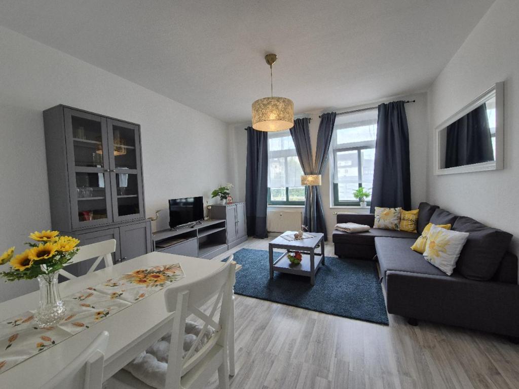 una sala de estar con un sofá y una mesa en Mikra Homes24 in Chemnitz, en Chemnitz