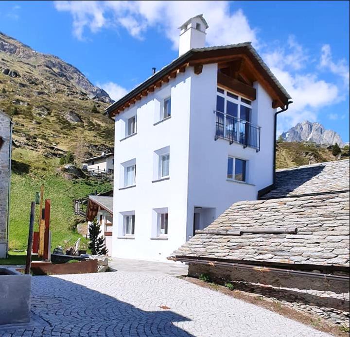 a white building with a balcony on top of it at Chesa Tre Piz in Maloja