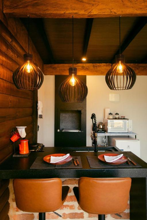 a kitchen with a table with two chairs and lights at Herança do Vovô02 in Domingos Martins