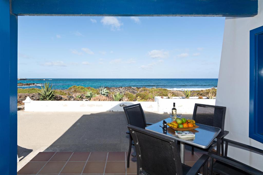 a table and chairs on a balcony with the beach at Blue Horizon Coast By PVL in Punta de Mujeres