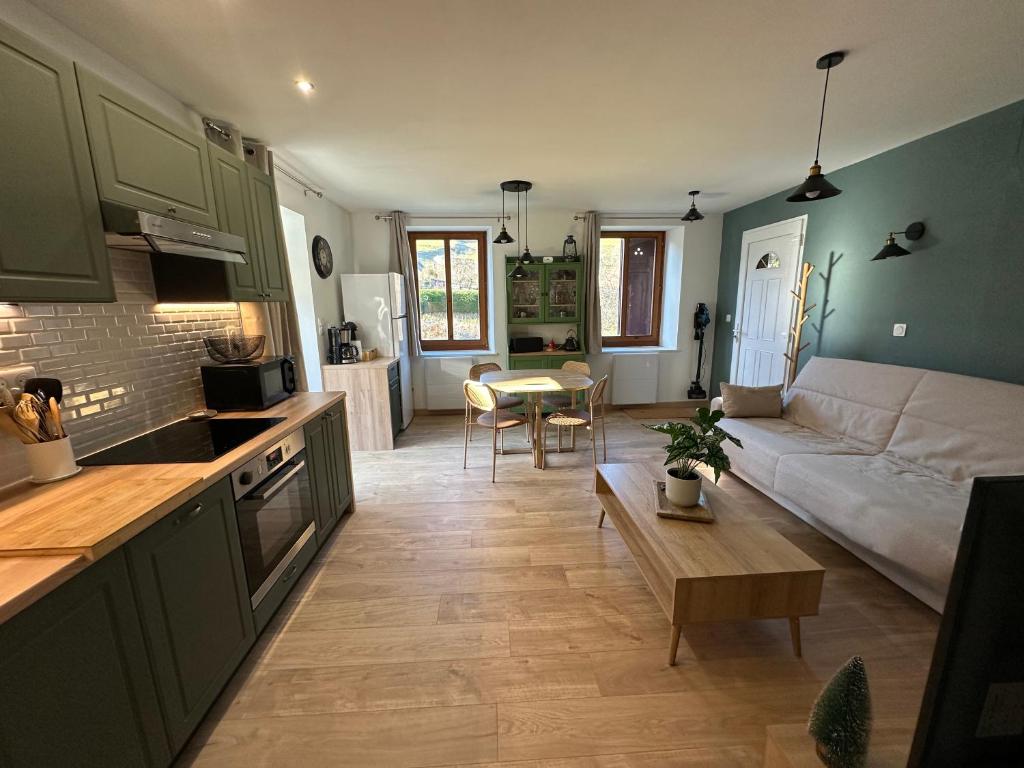 Appartement 4 personnes في أوربي: مطبخ وغرفة معيشة مع أريكة وطاولة