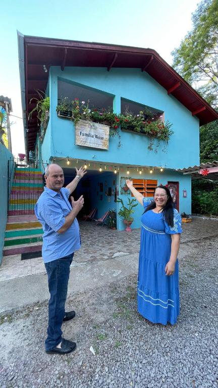 a man and a woman standing in front of a building at Pousada Recanto Gramado in Gramado