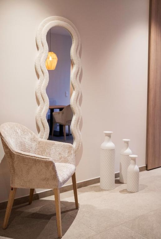 a chair in a room with a mirror and vases at Appartement Chalet Saalbach - incl Joker Card in Saalbach-Hinterglemm