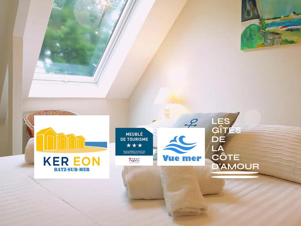 ein Zimmer mit Schildern auf einem Bett mit einem Fenster in der Unterkunft Ker Eon - Les Gîtes de la Côte d'Amour in Batz-sur-Mer