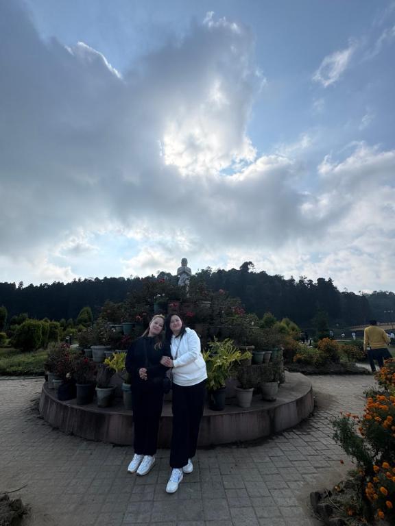 twee vrouwen poseren voor een foto voor een tuin bij Green Hill Home in Mirik