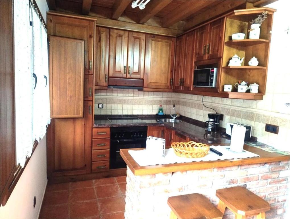 Una cocina con gabinetes de madera y encimera. en Casa Angelita, en Intriago