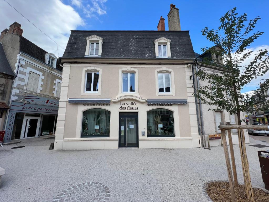 a white building with a black roof on a street at Chez Simone et Marguerite in Luzy