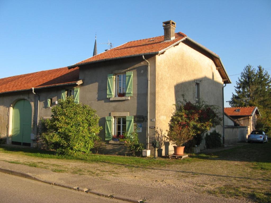 una casa bianca con persiane verdi su una strada di Au fil du temps 54 a Lironville
