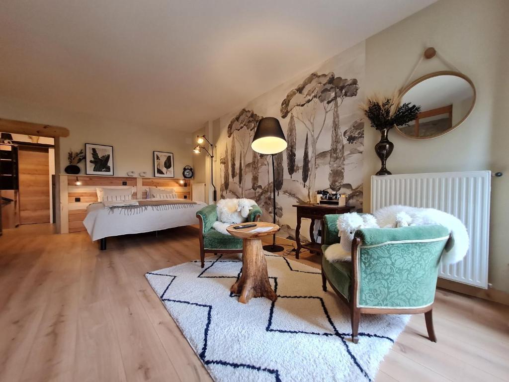 a living room with two chairs and a bed at Chambre 1, La Perpontaise in Boismont