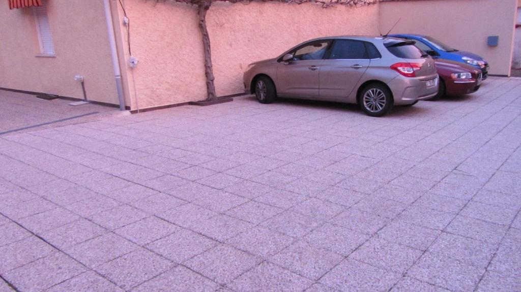 Un coche aparcado en un aparcamiento junto a un edificio. en Les Glycines, en Choloy