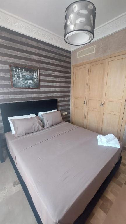 a large bed in a bedroom with a large white bed at Appartement Ksour in Sraghna