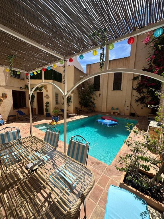 Casa del Patio في Pinos del Valle: فناء مع طاولة وكراسي ومسبح