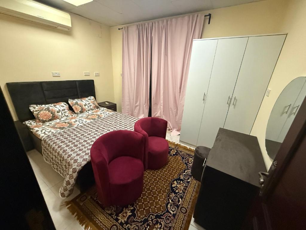 a bedroom with a bed and a chair and cabinets at Small apartment 10 minutes from Abu Dhabi Airport for Married Couple or Single with parking in Abu Dhabi