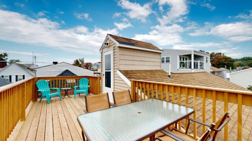 a wooden deck with a table and chairs on it at Sand Life #2 by Bayley Vacation Rentals in Old Orchard Beach