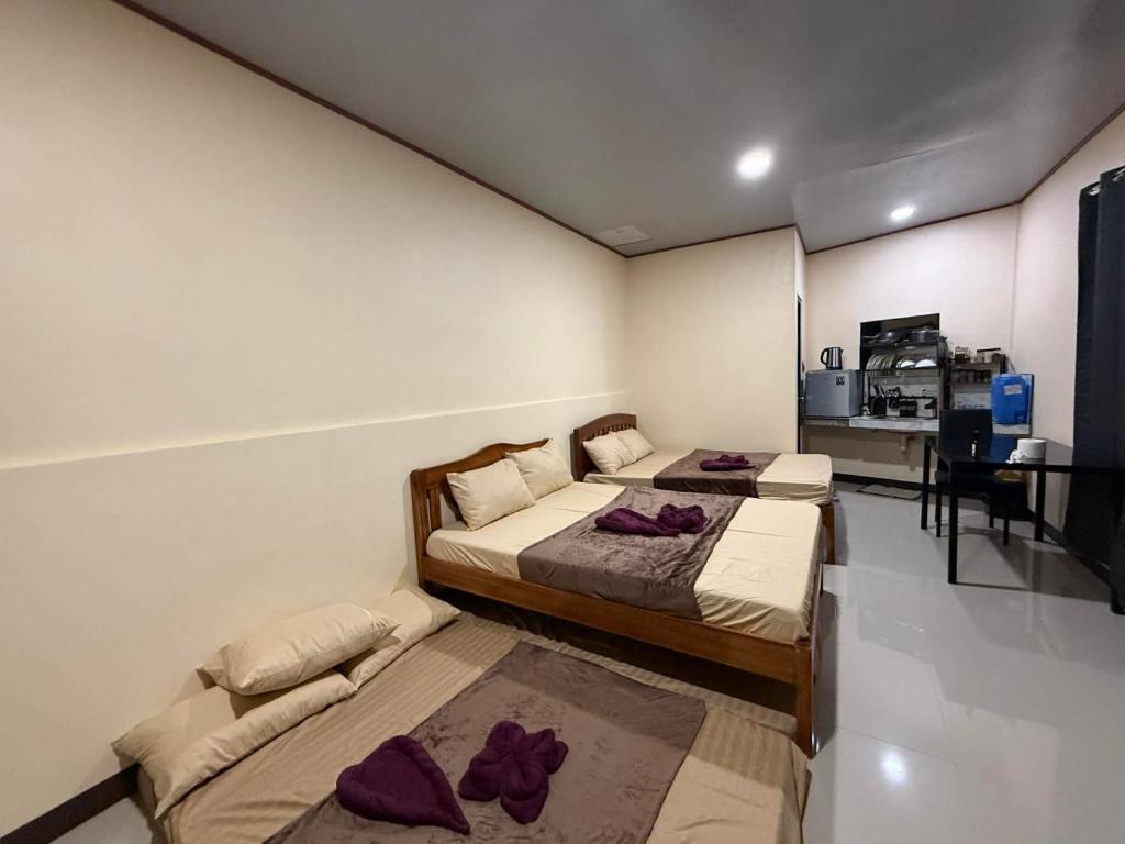 une chambre avec deux lits et un bureau dans l'établissement R&C Transient Extension, à El Nido