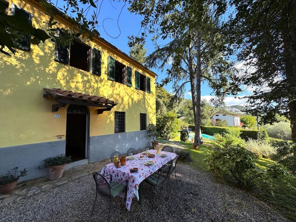a table in front of a yellow house with a table cloth at Allo Scoiattolo in Lucca