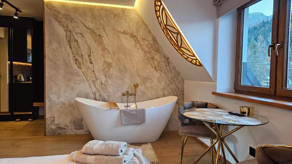 a bathroom with a large tub and a table at Willa Zielone Wzgórze - Zakopane - Luksusowe apartamenty in Zakopane