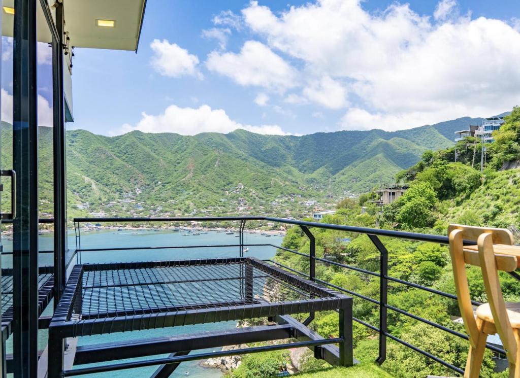 een balkon met een bank en uitzicht op de bergen bij Villa Malibu in Santa Marta